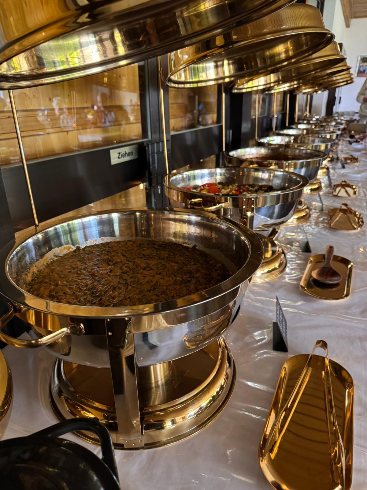 Long buffet table with gold chafing dishes